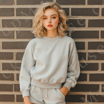 Womens grey sweatshirt mockup – lifestyle, brick wall backdrop; Gildan 18000 fit