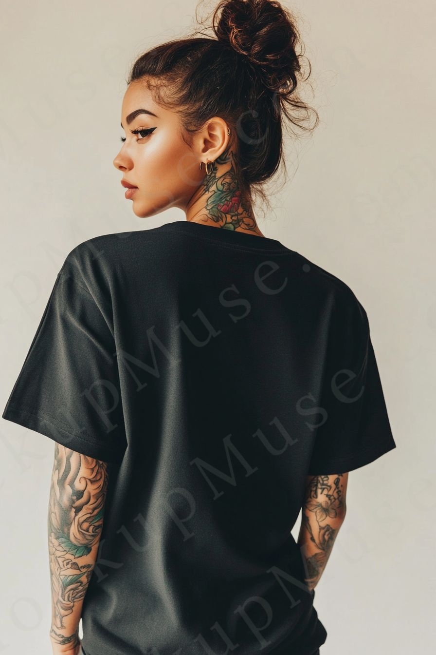 Vertical 2:3 women’s black onyx Gildan 5000 t‑shirt mockup, back view on gray‑taupe studio with tattooed arms visible; clean apparel template for online stores.