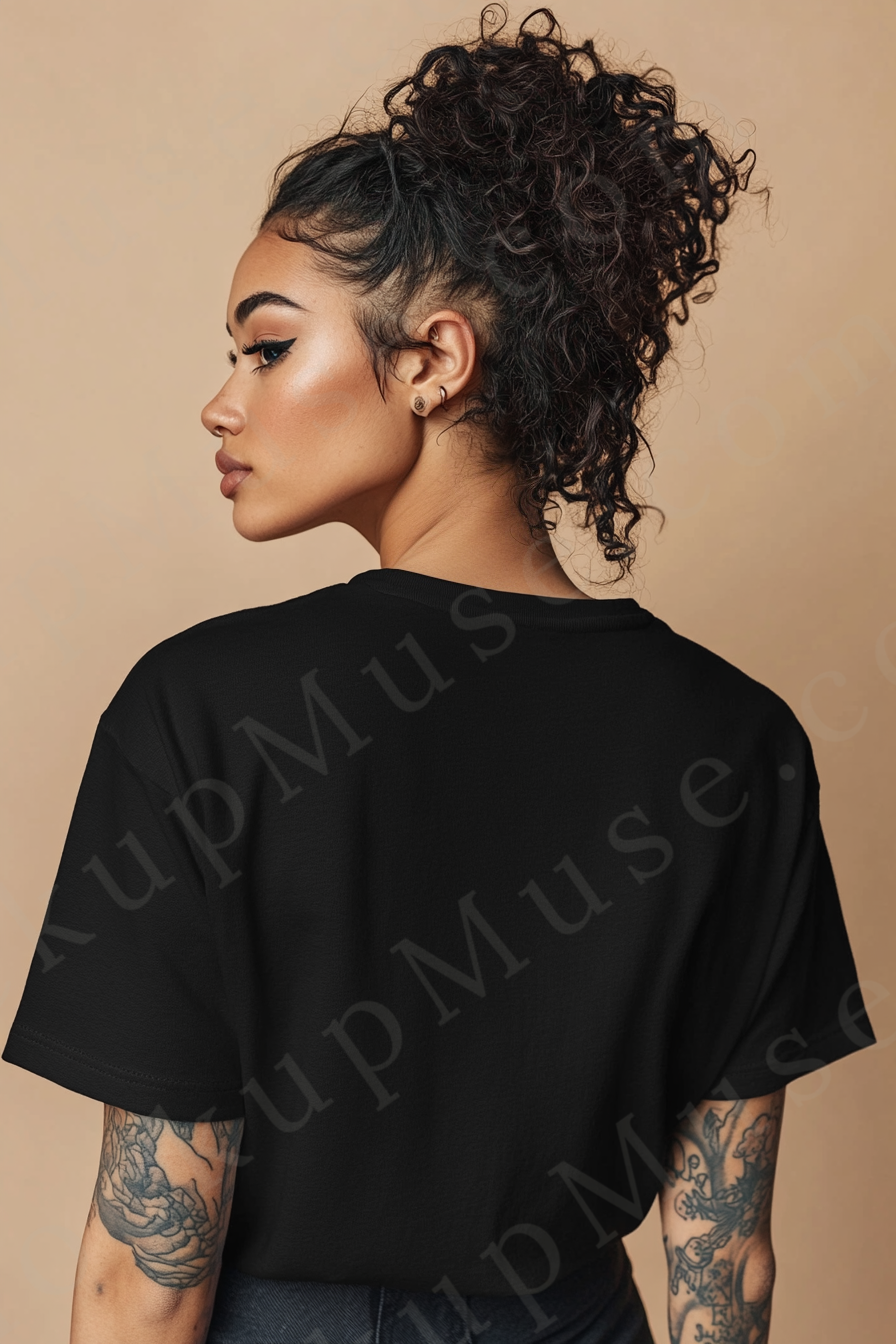 Vertical 2:3 women’s black onyx Gildan 5000 t‑shirt mockup, back view on tan studio with tattooed arms visible; clean apparel template for online stores.