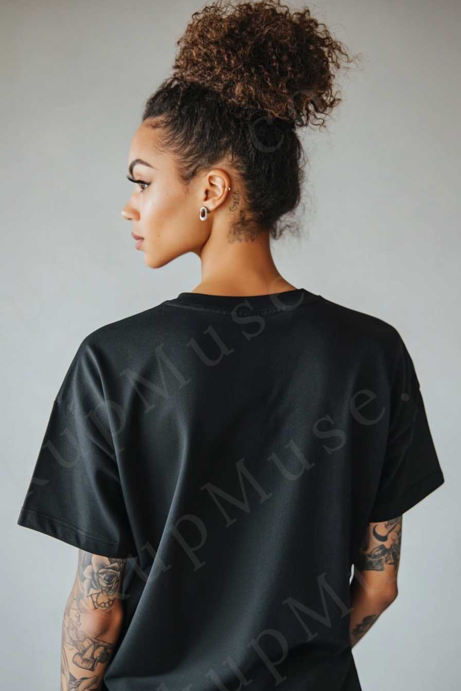 Vertical 2:3 women’s black onyx Gildan 5000 t‑shirt mockup, back view on light gray studio with tattooed arms visible; clean apparel template for online stores.